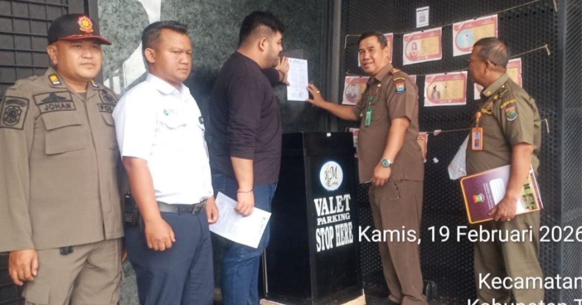 petugas Trantibum menempelkan Surat Imbauan Bupati dan MUI di salah satu tempat usaha, Kamis (19/2/2026).