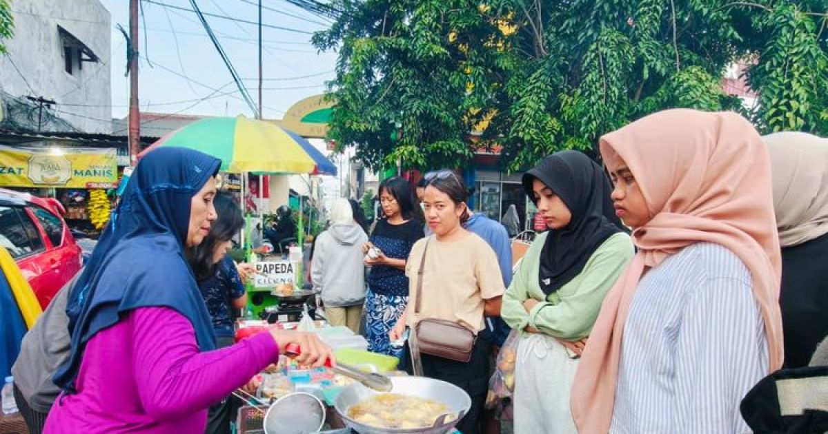 Sejumlah pembeli sedang menunggu gorengan sebelum buka puasa yang setiap harinya dipadati warga untuk membeli takjil, tradisi di bulan Ramadhan di kawasan Karang Menjangan Surabaya, Jawa Timur, Jumat (20/2/2026) sore.(KOMPAS.Com/Suci Rahayu)