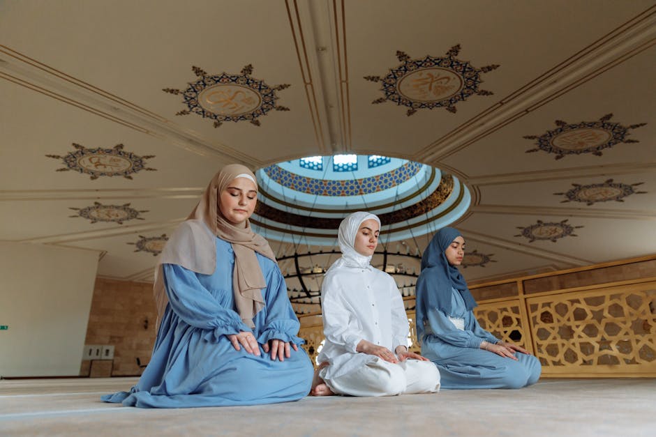 Foto sebuah naskah klasik kitab kuning yang terbuka di atas meja kayu dengan pencahayaan hangat, di sampingnya terdapat tasbih kayu dan latar belakang interior masjid yang memiliki arsitektur geometris Islam yang tenang dan megah.