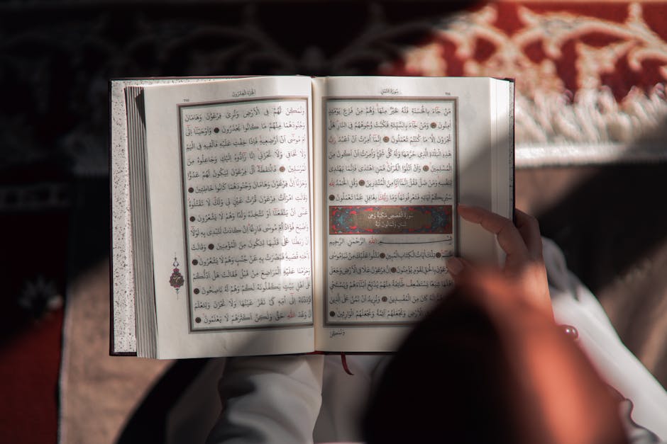 Foto sebuah mushaf Al-Quran yang terbuka dengan pencahayaan hangat di dalam sebuah perpustakaan klasik yang dipenuhi kitab-kitab turats, melambangkan kedalaman ilmu dan kejernihan cahaya tauhid di tengah kegelapan zaman.