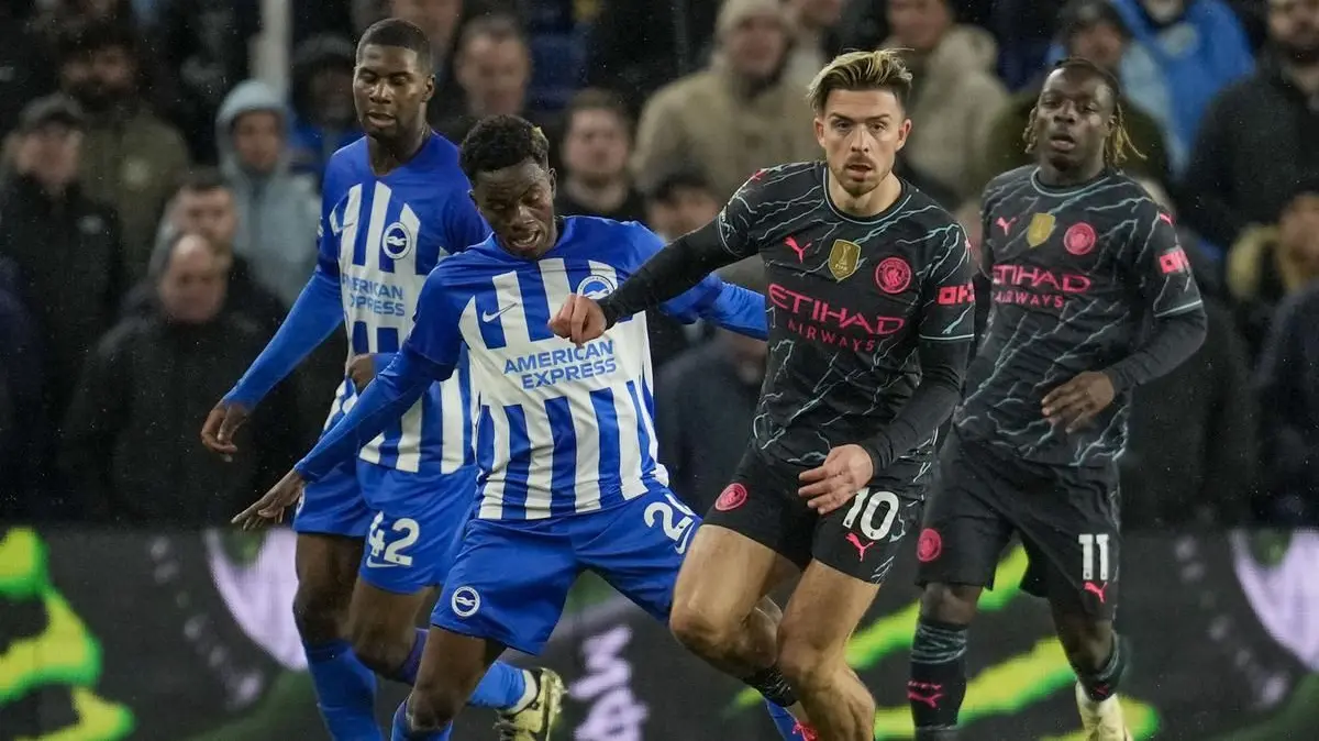 Jack Grealish dari Manchester City, kanan depan, berebut bola dengan pemain Brighton Carlos Baleba selama pertandingan sepak bola Liga Premier Inggris antara Brighton dan Manchester City di Stadion Falmer di Brighton, Inggris, Kamis, 25 April 2024. (AP Ph