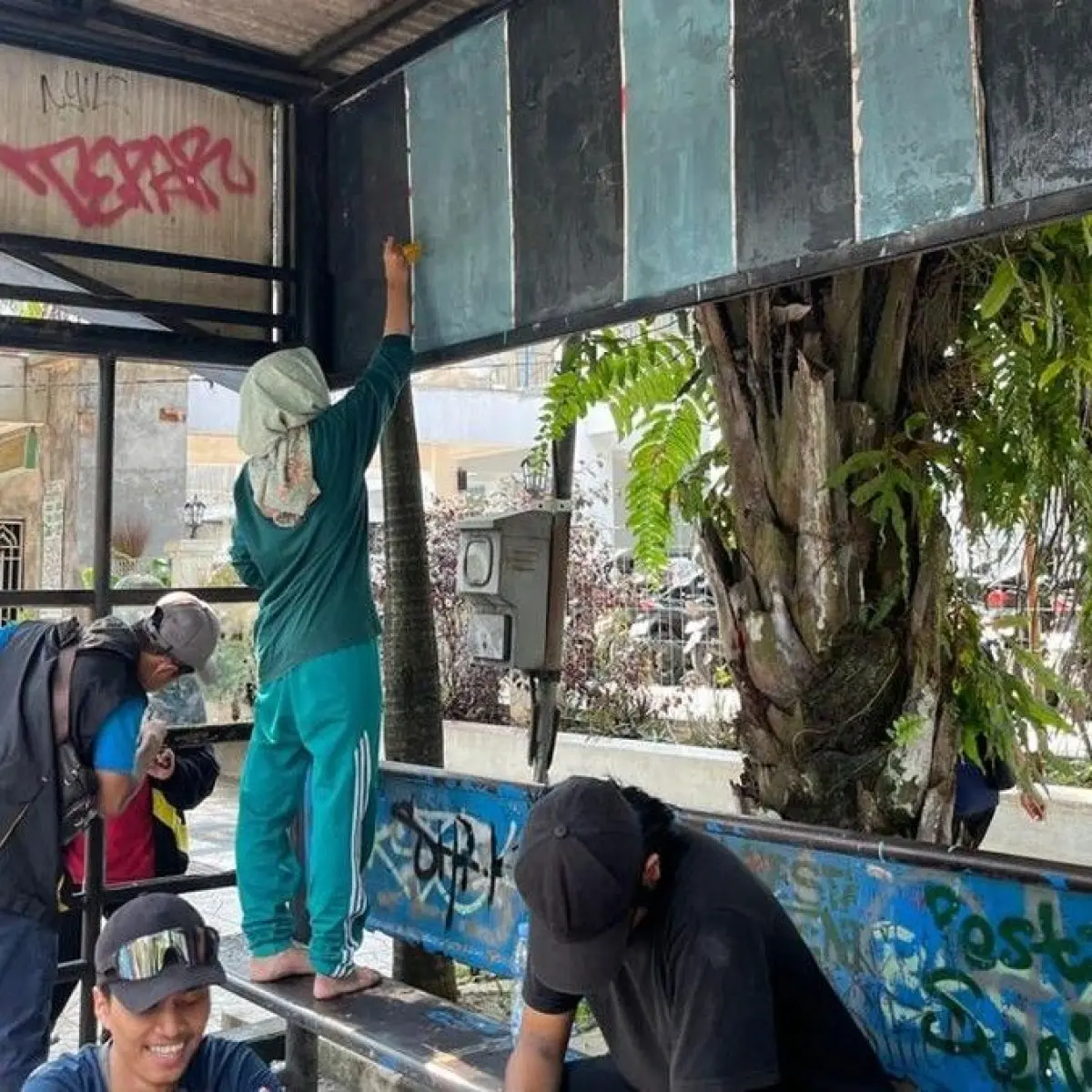 Warga mengecat halte transjatim (Foto: Muhammad Aminudin/ detikjatim)