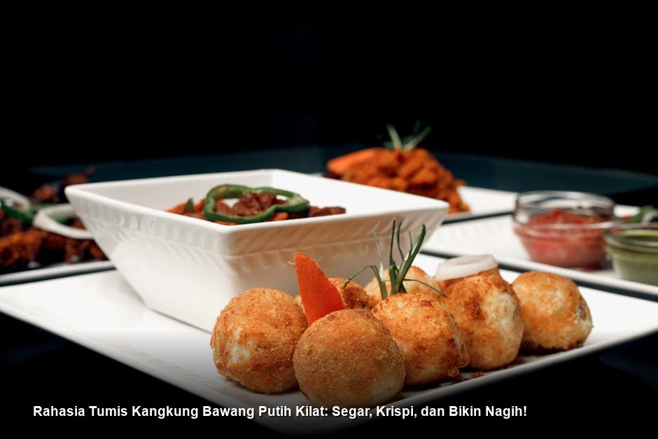 Semangkuk tumis kangkung bawang putih yang baru diangkat dari wajan, warnanya hijau cerah kontras dengan taburan bawang putih goreng, tampak sangat menggugah selera.