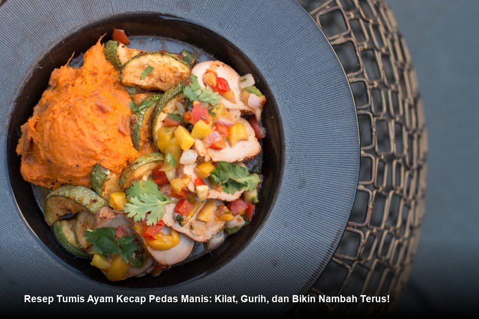 Piring saji berisi Tumis Ayam Kecap Pedas Manis yang mengkilap, ditaburi irisan daun bawang segar dan disajikan dengan nasi putih pulen.