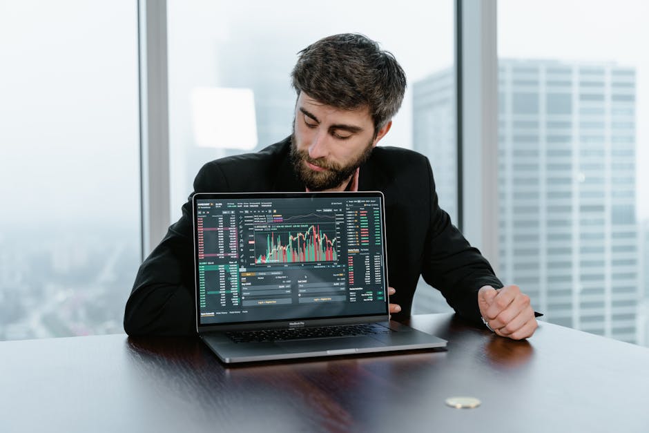 Tampilan layar laptop yang menunjukkan chart candlestick profesional dengan indikator Moving Average dan RSI yang berwarna-warni di atas meja kerja yang bersih.