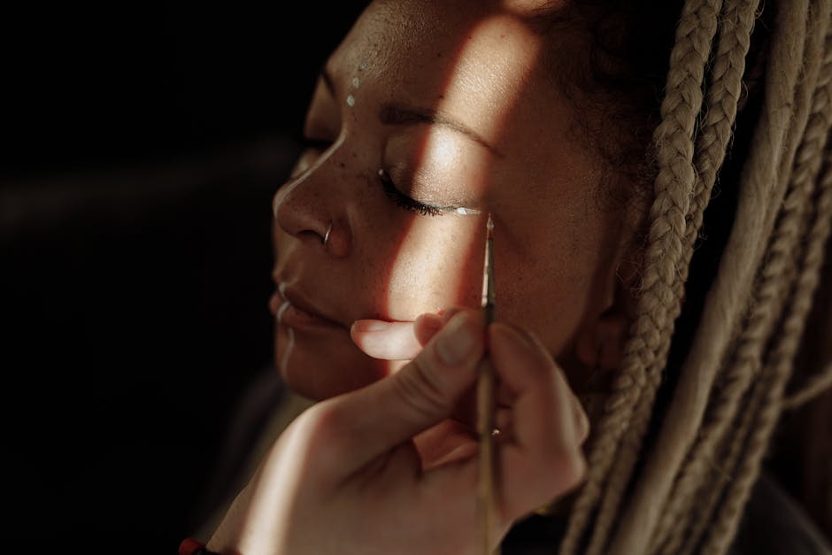 Seorang wanita tersenyum sambil mengaplikasikan pelembap atau tabir surya ke wajahnya di pagi hari.